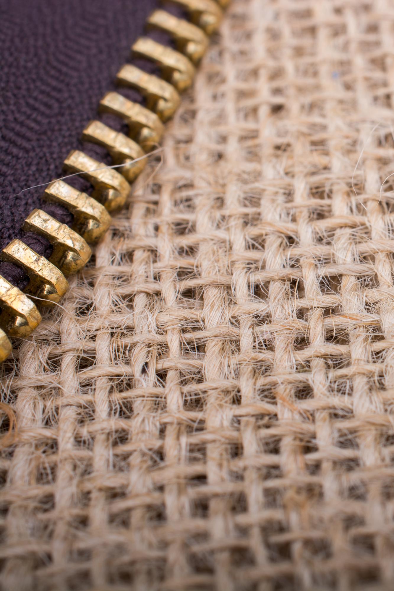 detail of hand embroidery on linen with gold thread