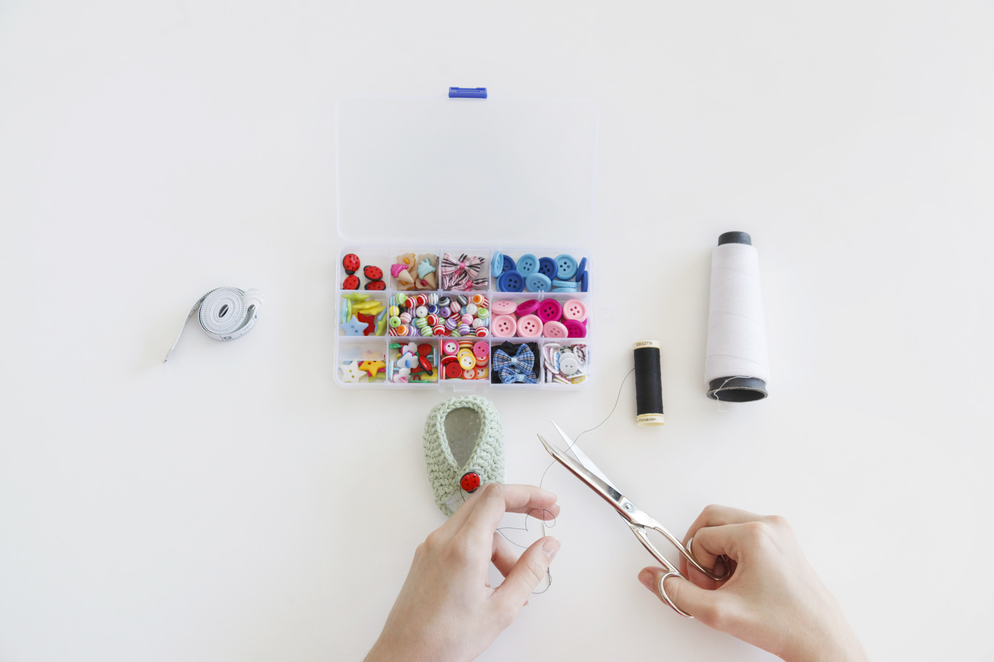 artist hands arranging thread samples on paper